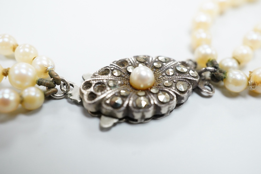A triple strand graduated cultured pearl necklace, with marcasite set sterling clasp(a.f.), approximately 38cm.
